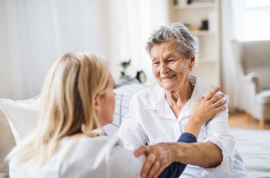 elderly woman smiling at healthcare professional
