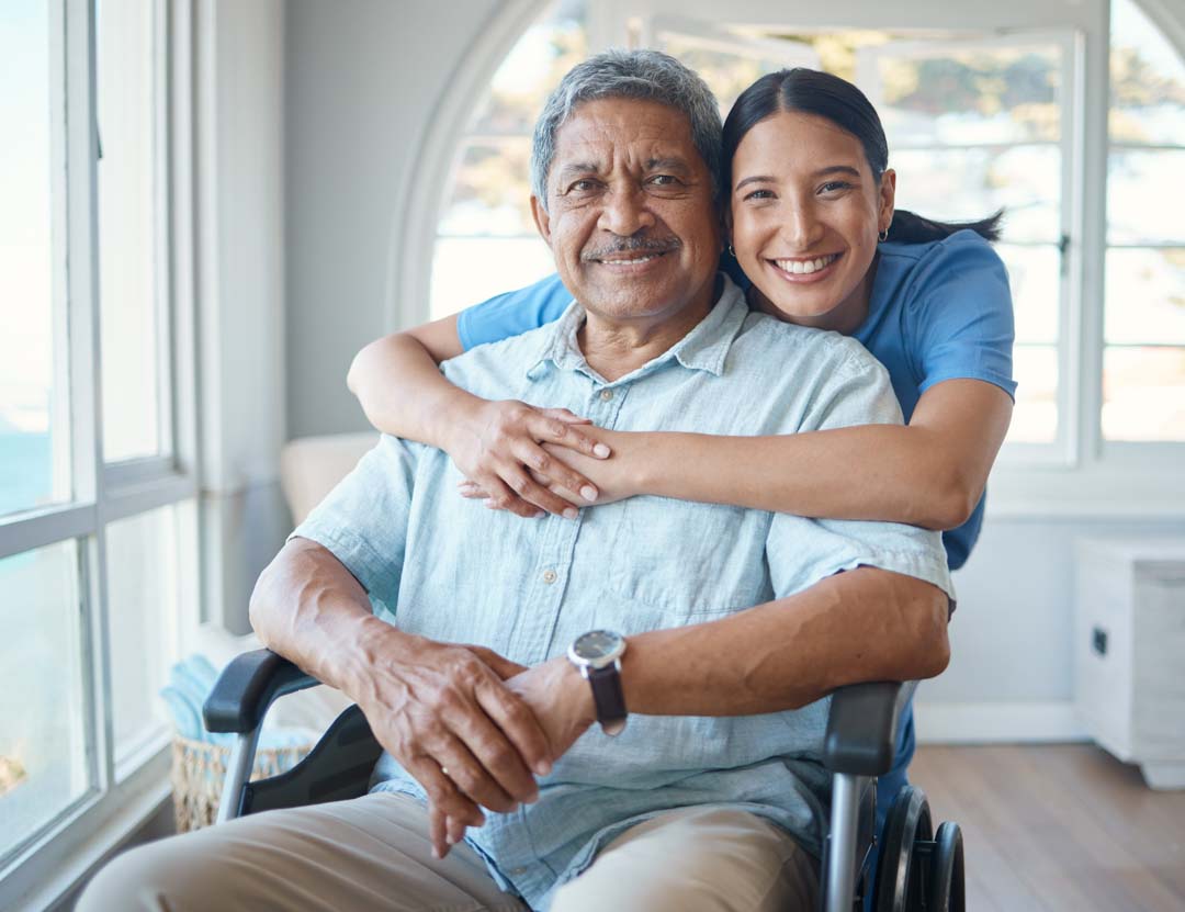 smiling senior man in wheelchair with nurse in home