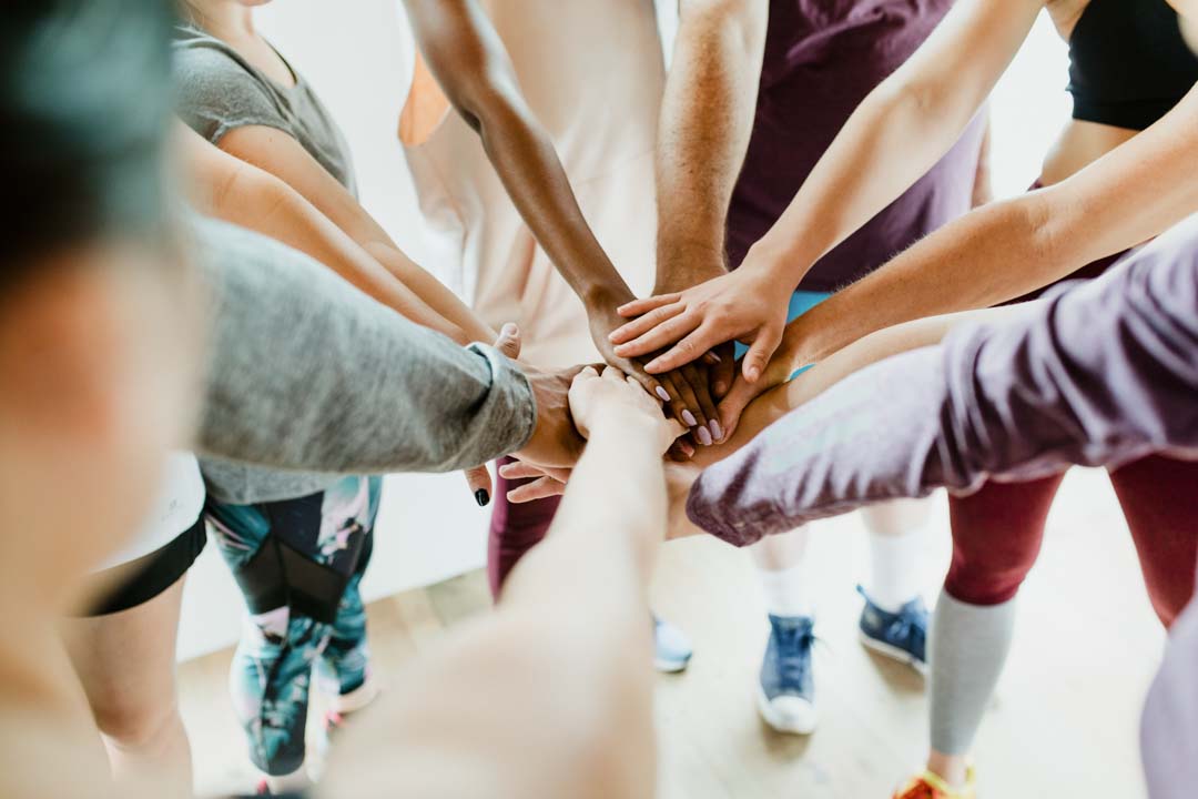 group of diverse people stacking hands