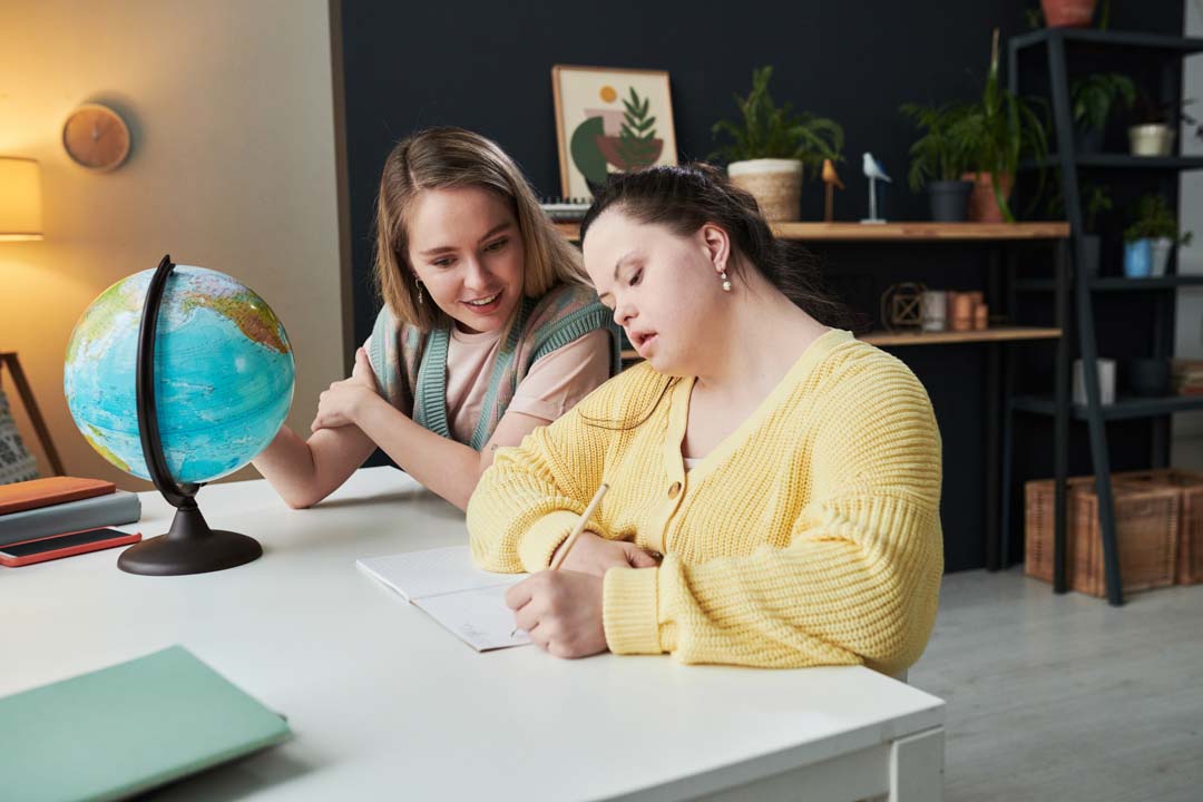 student taking notes during geography lesson with teacher