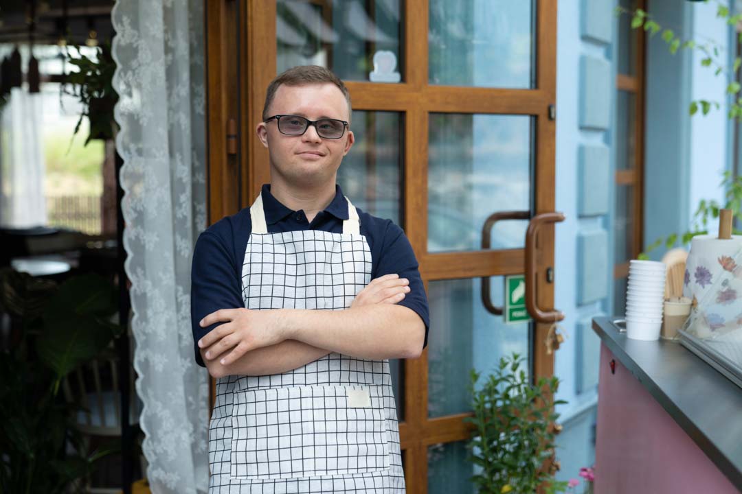 smiling food service employee with down syndrome wearing an apron