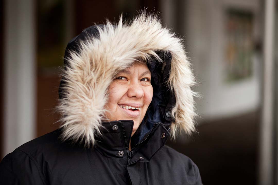 smiling woman with down syndrome wearing a hooded coat