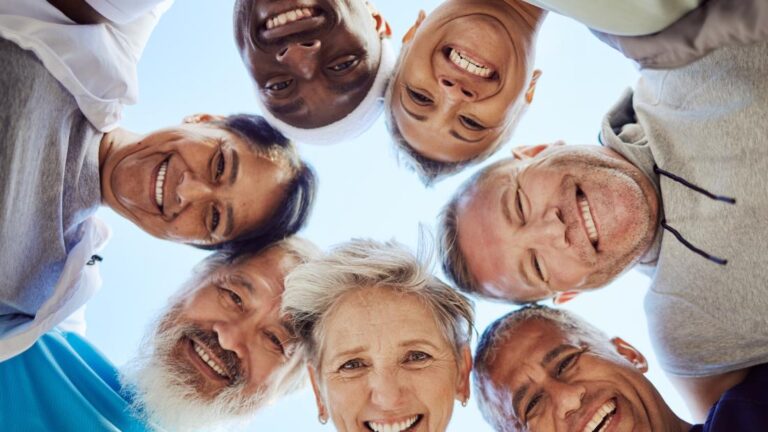 circle of seniors smiling over a camera