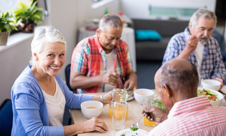 senior woman eating food with friends