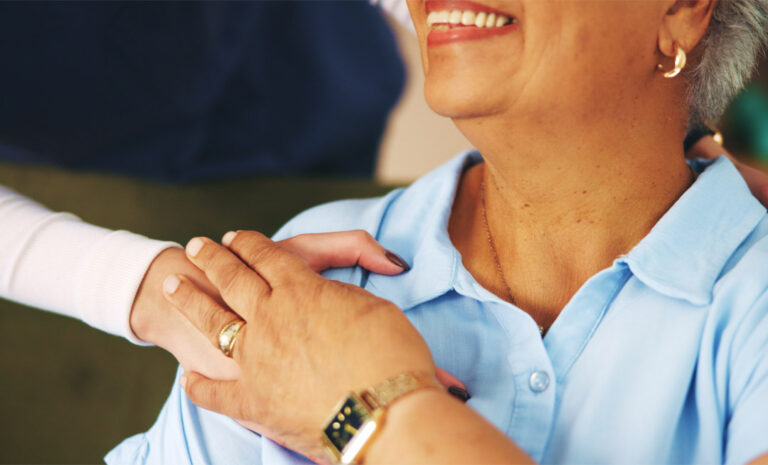 senior woman holding nurse's hand with gratitude