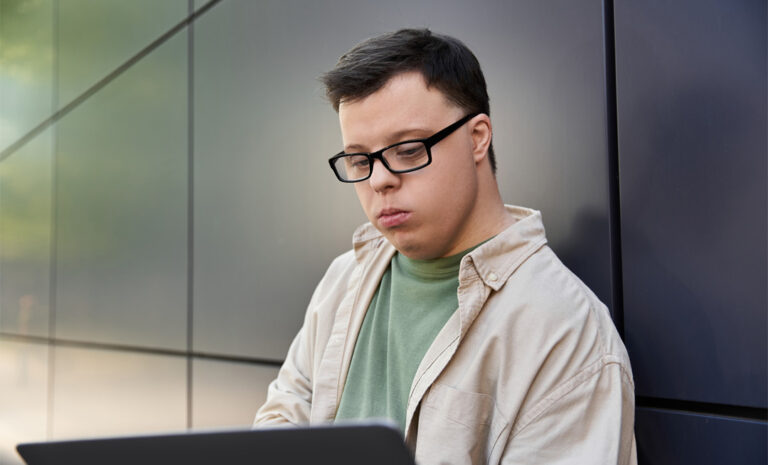 young man with down syndrome working on laptop