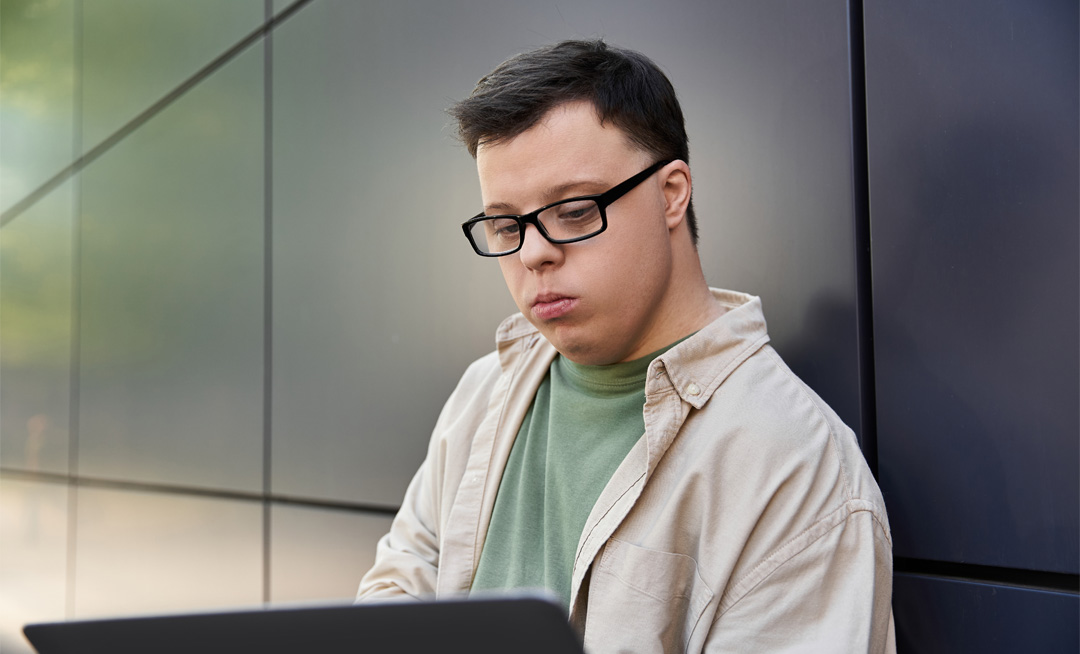 young man with down syndrome working on laptop