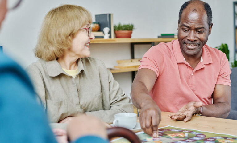 Senior people playing game at table